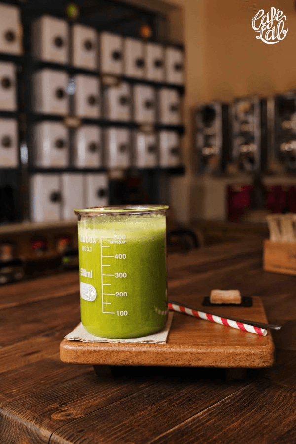Zumo verde en vaso de cristal medidor